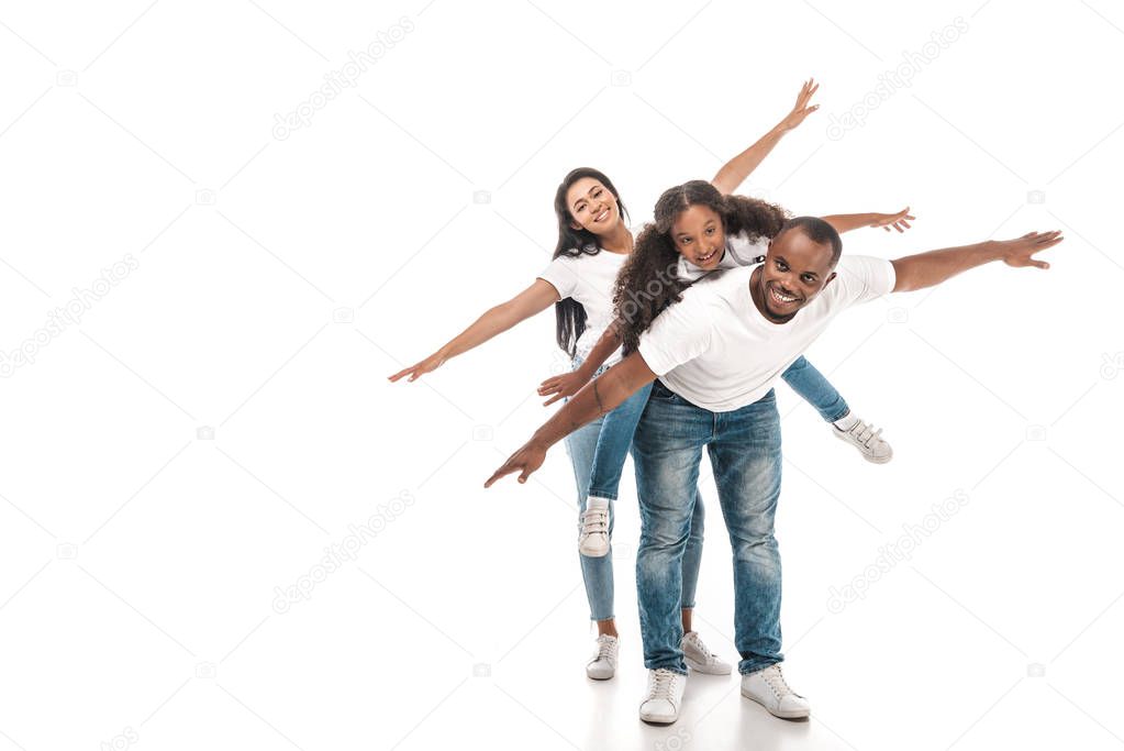 cheerful african american family imitating flying with outstretched hands on white background