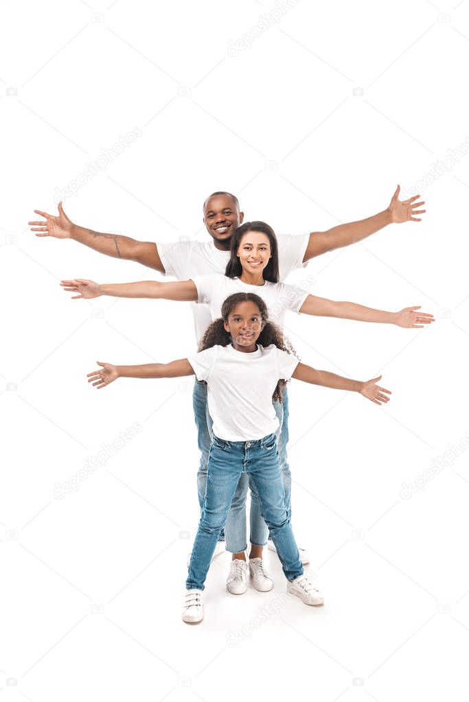 cheerful african american kid with parents imitating flying with outstretched hands on white background