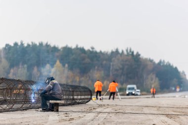 LVIV, UKRAINE - 23 Ekim 2019: koruyucu maske ve tek kaynaklı metalik yapı kaynakçılarının seçici odak noktası
