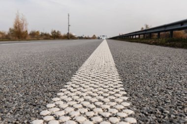 Boş otoyoldaki gri asfaltta şeridin seçici odak noktası 