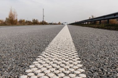 selective focus of lane on grey asphalt on empty highway  clipart