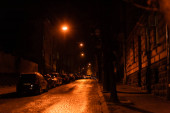 LVIV, UKRAINE - 23. OKTOBER 2019: Autos parken nachts auf der Straße in der Nähe von Straßen und Gebäuden 