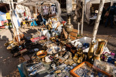 LVIV, UKRAINE - OCTOBER 23, 2019: vendor on flea market near stall with vintage cutlery, souvenirs and jewelry