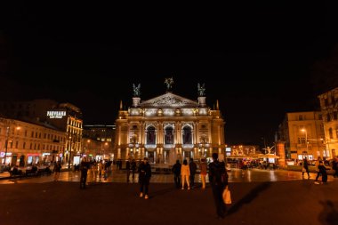 LVIV, UKRAINE - 23 Ekim 2019: insanlar geceleri lviv Ulusal Operası 'nın yakınında yürüyorlar 