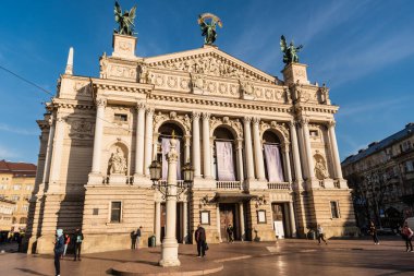 LVIV, UKRAINE - OCTOBER 23, 2019: Lviv Theatre of Opera and Ballet with people walking around clipart