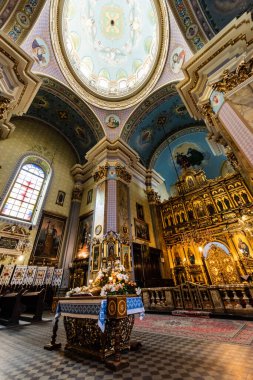 LVIV, UKRAINE - 23 Ekim 2019: Yaldızlı sunak ve güzel resimlerle düşük açılı karmelit kilise içi