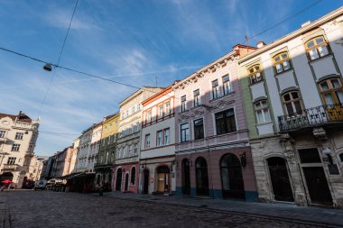 LVIV, UKRAINE - 23 Ekim 2019: şehir merkezinde mavi gökyüzüne karşı güzel otantik evler