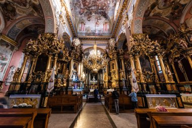 LVIV, UKRAINE - 23 Ekim 2019: resimli, yaldızlı sütunlu ve avizeli Carmelite kilisesinin içi