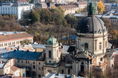 LVIV, UKRAINE - 23 Ekim 2019: latin harflerle çevrili, yeşil ağaçlarla çevrili Dominik Kilisesi 'nin havadan görünüşü