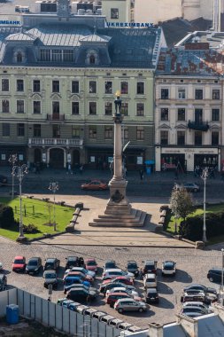 LVIV, UKRAINE - 23 Ekim 2019: Adam Mickiewicz Anıtı 'nın otopark ve otantik evler yakınındaki havadan görünüşü 