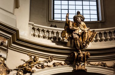 LVIV, UKRAINE - OCTOBER 23, 2019: gilded male statue near balcony with balustrade in dominican church clipart