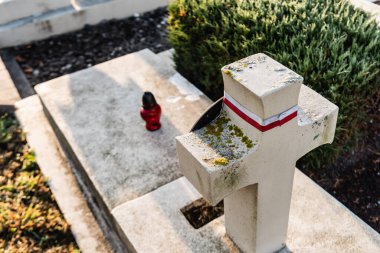 LVIV, UKRAINE - OCTOBER 23, 2019: high angle view of polish tomb with stone cross in lychakiv cemetery in lviv, ukraine clipart