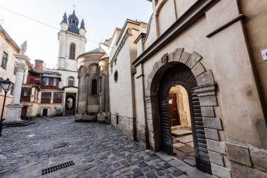street leading to carmelite church and monastery wall with arch in lviv, ukraine clipart