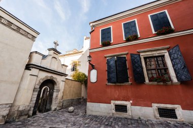 lviv, Ukrayna 'da kapısı olan kemer yakınındaki pencereli kırmızı eski ev.