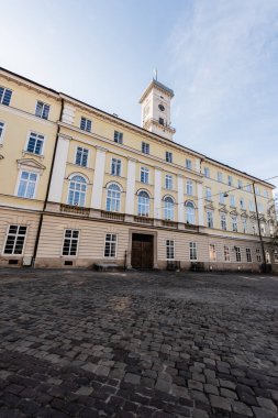 Lviv belediye binasının ön cephesinde, Lviv, Ukrayna 'da mavi gökyüzüne karşı kule var.