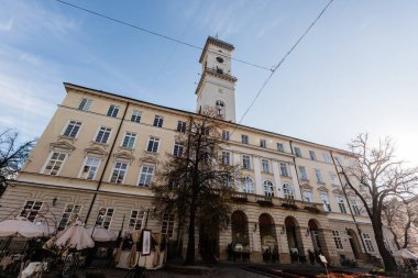 Lviv belediye binasının ön cephesinde, Lviv, Ukrayna 'da mavi gökyüzüne karşı kule var.