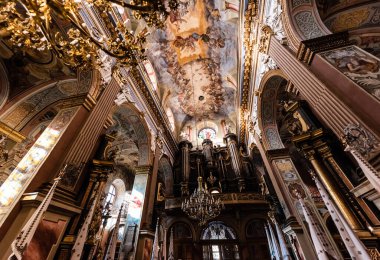 LVIV, UKRAINE - 23 Ekim 2019: Carmelite Kilisesi 'ndeki güzel resimli sütunların ve tavanın alçak açılı görüntüsü