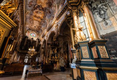 LVIV, UKRAINE - OCTOBER 23, 2019: interior of carmelite church with paintings on ceiling and walls, and gilded columns clipart