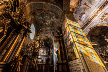 LVIV, UKRAINE - OCTOBER 23, 2019: low angle view of interior with paintings and gilded decoration in carmelite church clipart
