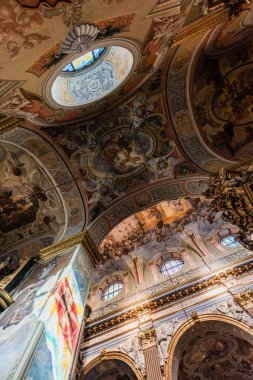 LVIV, UKRAINE - OCTOBER 23, 2019: bottom view of arch and ceiling with paintings in carmelite church clipart