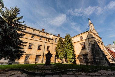 Iviv, Ukrayna 'da mavi gökyüzüne karşı yeşil köknar bulunan Bernardine Manastırı' nın iç avlusu.