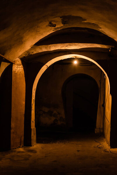 arch and old walls in ancient basement at night 