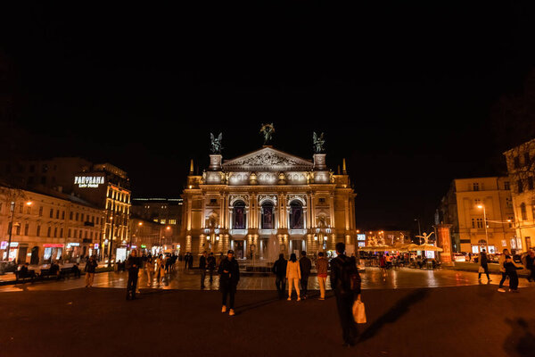 Львов, Украина - 23 октября 2019 года: люди, гуляющие возле Львовской национальной оперы ночью
 