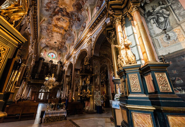 LVIV, UKRAINE - OCTOBER 23, 2019: interior of carmelite church with paintings on ceiling and walls, and gilded columns