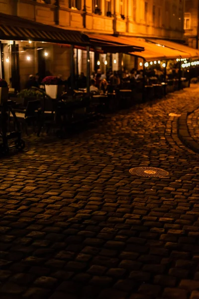 Selective focus of paving stones on road near cafe with terrace — Stock Image Selective Focus Paving Stones Road Cafe Terrace Royalty Free Stock Photos