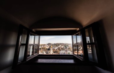 scenic view of latin cathedral and carmelite church through open window in lviv, ukraine clipart