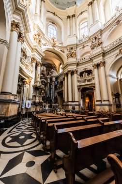 LVIV, UKRAINE - 23 Ekim 2019: Tahta bankları, mozaik zemini ve yaldızlı süslemeleri olan Dominik kilisesinin içi