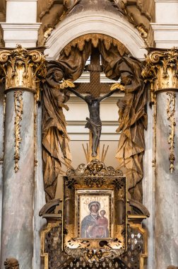 LVIV, UKRAINE - 23 Ekim 2019: Dominik kilisesinde mermer sütunlar ve yaldızlı sütunlar arasında ikon ve haç