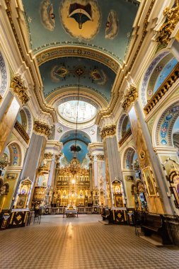 LVIV, UKRAINE - OCTOBER 23, 2019: interior of carmelite church with gilded altar, paintings on walls and tiled floor clipart