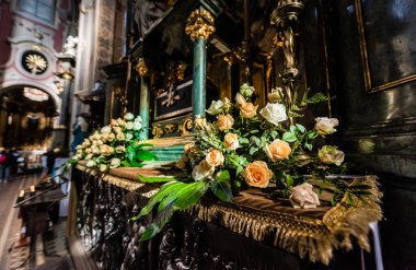 LVIV, UKRAINE - OCTOBER 23, 2019: altar of carmelite church decorated with natural roses clipart