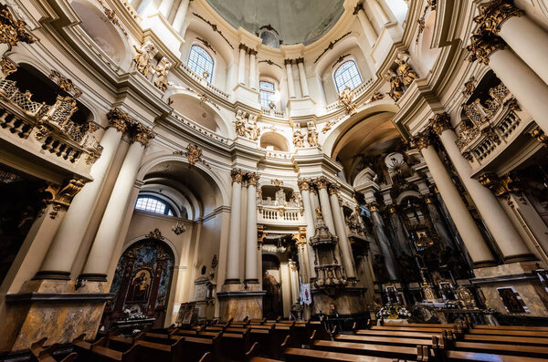 LVIV, UKRAINE - OCTOBER 23, 2019: baroque interior of dominican church with wooden benches and gilded decorative elements