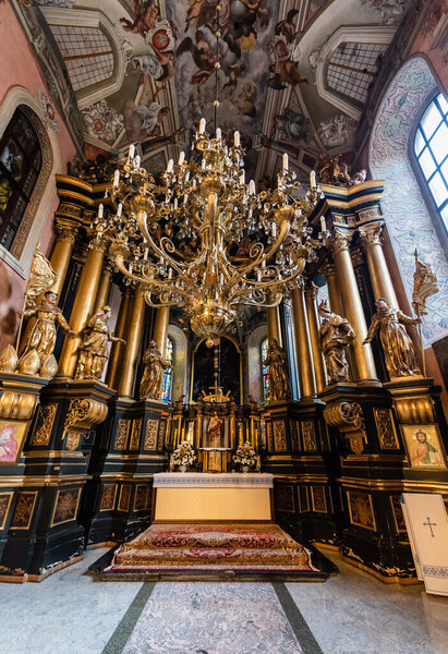 LVIV, UKRAINE - OCTOBER 23, 2019: interior of carmelite church with gilded columns, statues and chandelier