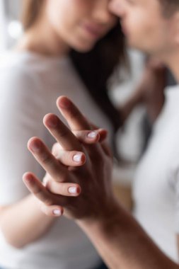 Evde el ele tutuşan kadın ve erkeğin seçici odağı 