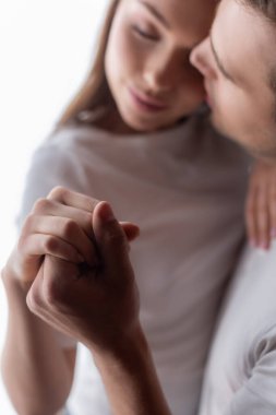 Evde el ele tutuşan erkek ve genç kadının seçici odağı 