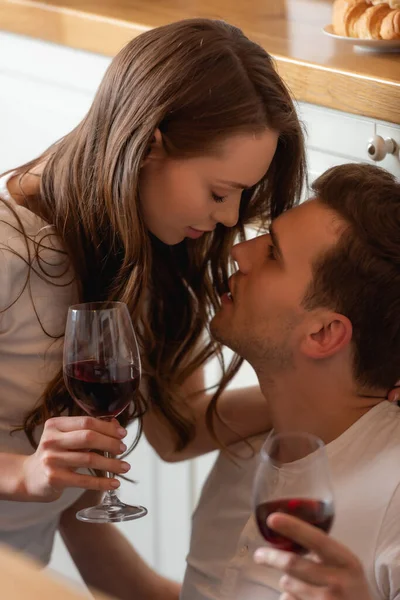眼睛闭着的年轻女子和举着红葡萄酒眼镜的男子的侧视图 — 图库照片