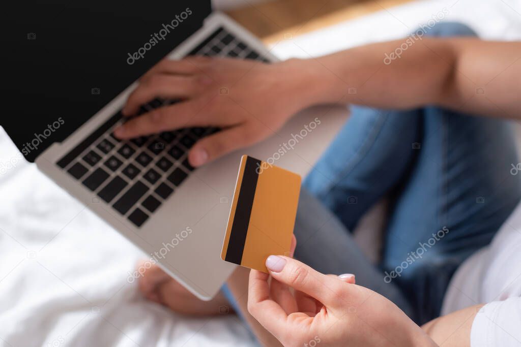 cropped view of man using laptop and woman holding credit card 