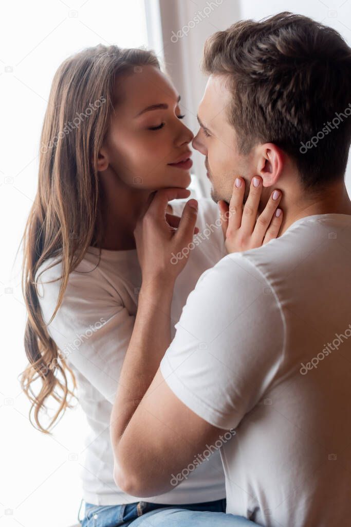 handsome man touching face of beautiful woman at home 