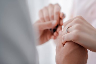 Nişan yüzüğü parmağında erkeğin elini tutan seçici bir kadın. 