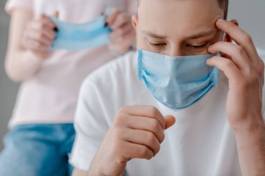 Tıbbi maskeli bir adamın kadınlara dokunuşunun seçici odağı