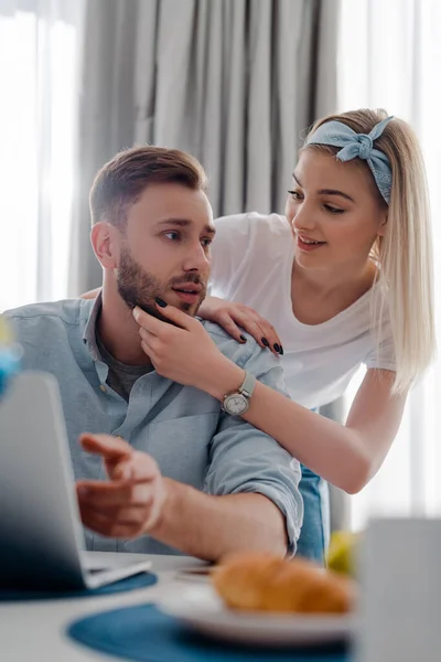 幸せな女の子の選択的焦点ノートパソコンの近くでフリーランスのボーイフレンドに触れる — ストック写真