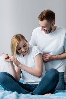 seçici odak noktası neşeli adam gıdıklayan kız yatak odasında 