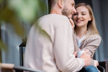 Mutlu adama bir bardak içkiyle dokunan neşeli kızın seçici odağı. 