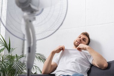 pozitif adam yaz sıcağında evde elektrikli vantilatörle rahat hisseder. 