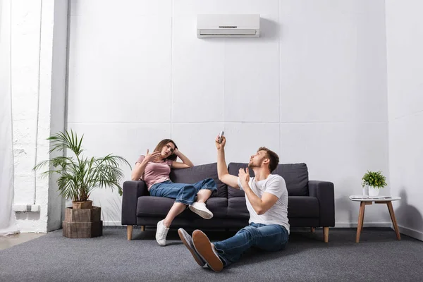 Triest Paar Met Afstandsbediening Thuis Met Kapotte Airconditioner — Stockfoto