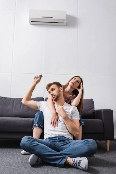 Verward Paar Met Afstandsbediening Lijden Aan Warmte Terwijl Thuis Zitten — Stockfoto