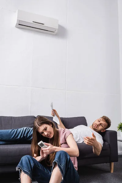 Jovem Casal Com Controlador Remoto Jornal Sofrendo Calor Enquanto Sentado — Fotografia de Stock